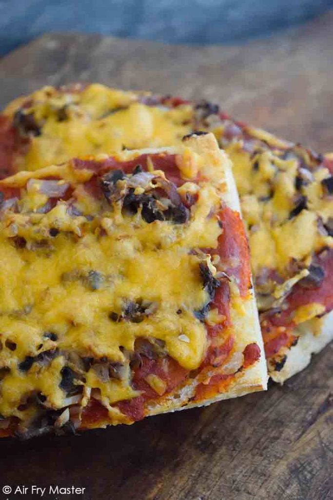 And up close view of these Air Fryer French Bread Pizzas on a cutting board.