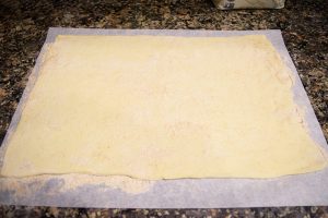 Step one is to flatten out your puff pastry on a floured surface.