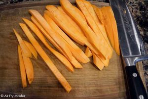 Cut the sweet potatoes into fries after peeling them.