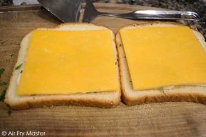The next layer on the bread slices is the cheese on either side.
