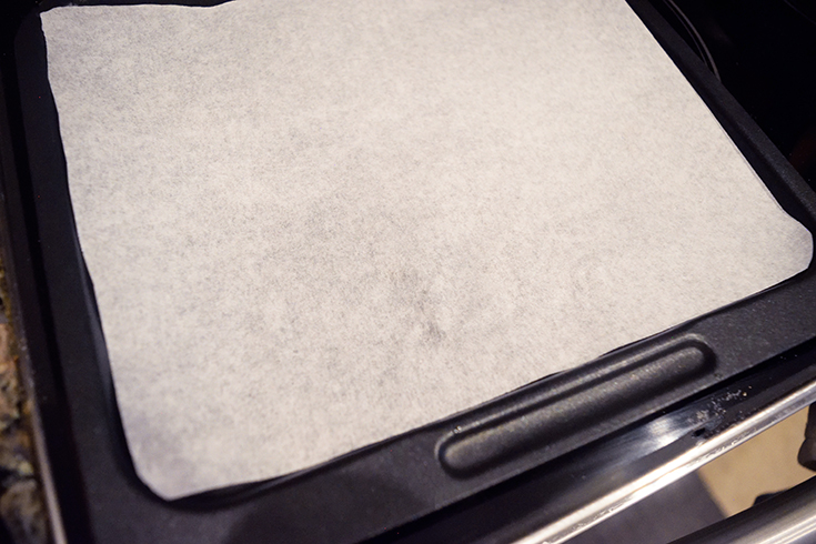 The parchment-lined air fryer tray.