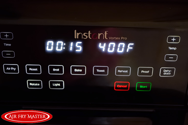 The control panel on the air fryer showing a time of 15 minutes and a temperature of 400 F.