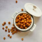 Air Fryer Chickpeas in a small crock with the lid resting on the side of the crock.