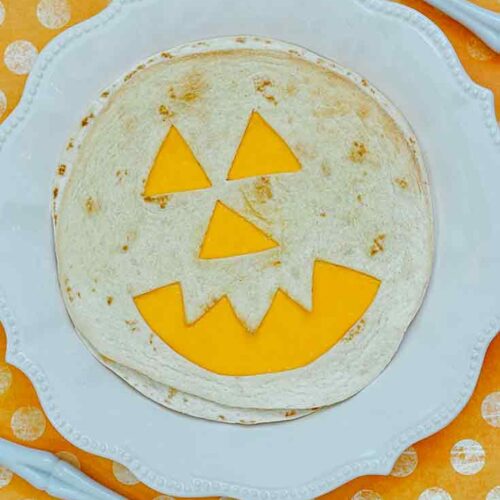 A single quesadilla on a white plate showing the final result of this Air Fryer Jack-O-Lantern Quesadillas Recipe