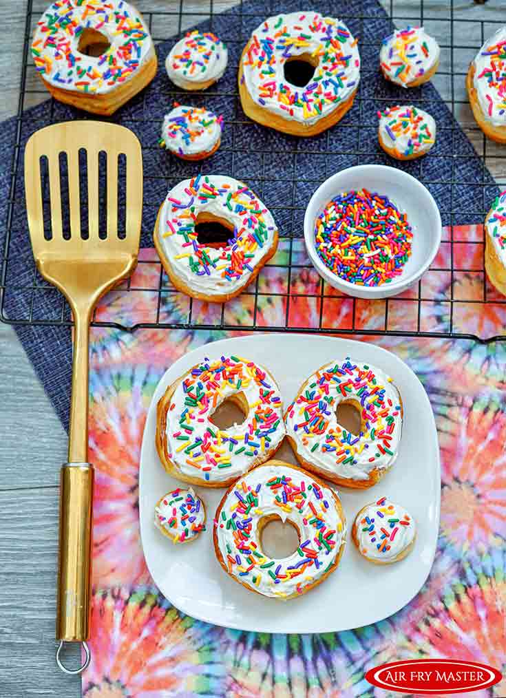 A white platter filled with Air Fryer Donuts Recipe With Sprinkles.