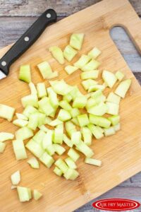 The peeled, seeded and cut cucumber on a cutting board.
