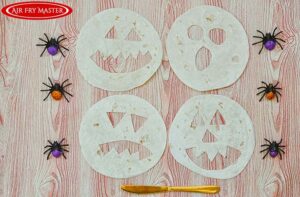 Four different Jack-O-Lantern faces cut out of tortillas.