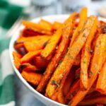 Close up of a white bowl filled with Air Fryer Carrot Fries.