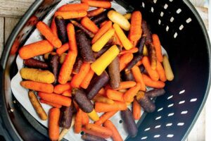 The finished Air Fryer Glazed Carrots still sitting in the air fryer basket they were cooked in.