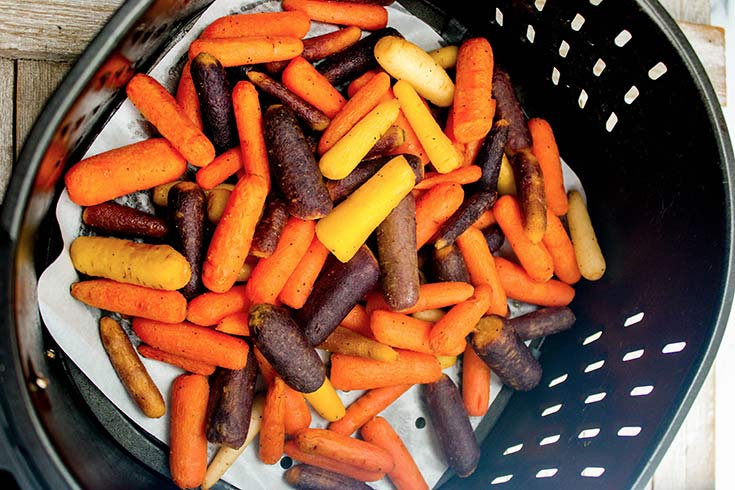 The finished carrots still sitting in the air fryer basket they were cooked in.