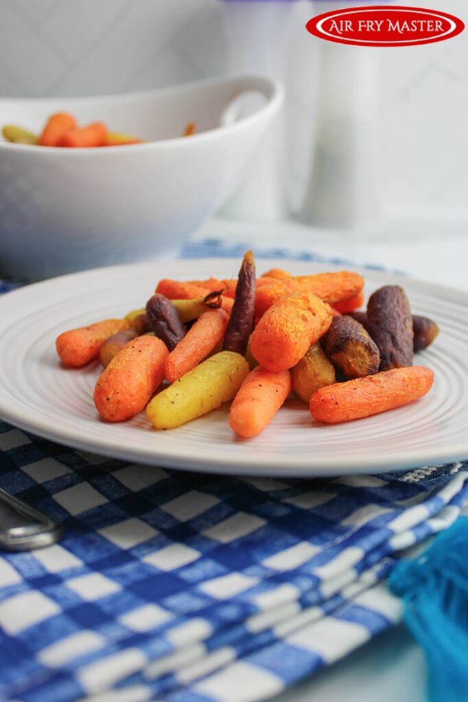 Air Fried carrots sit on a white plate.