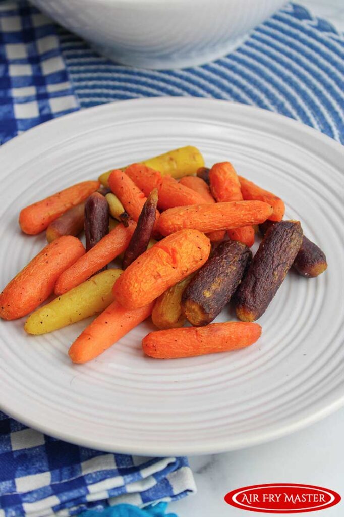 An overhead view of Air Fryer Glazed Carrots on a white, round plate.