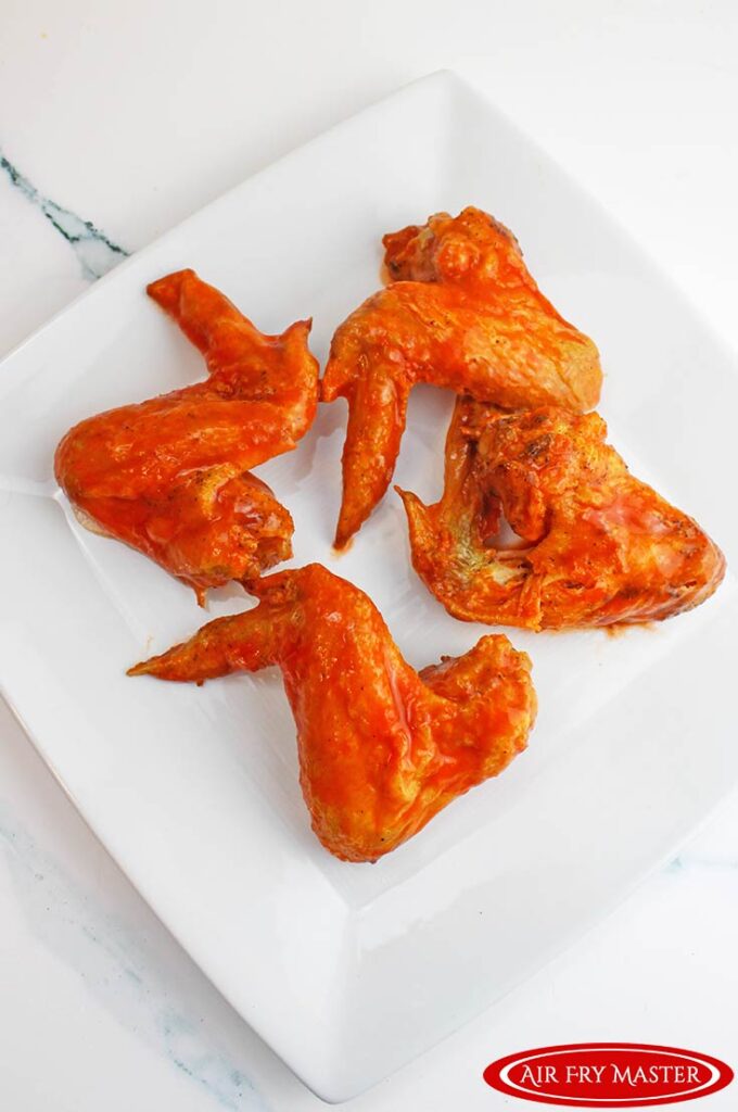 An overhead view of Air Fryer Chicken Wings on a square, white platter.