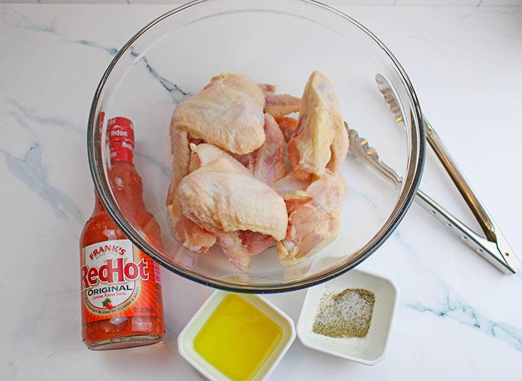 Air Fryer Chicken Wings Recipe ingredients gathered on a white marble surface.
