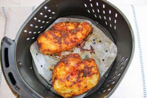 Just cooked Air Fryer Chicken Breasts sitting in an air fryer basket.