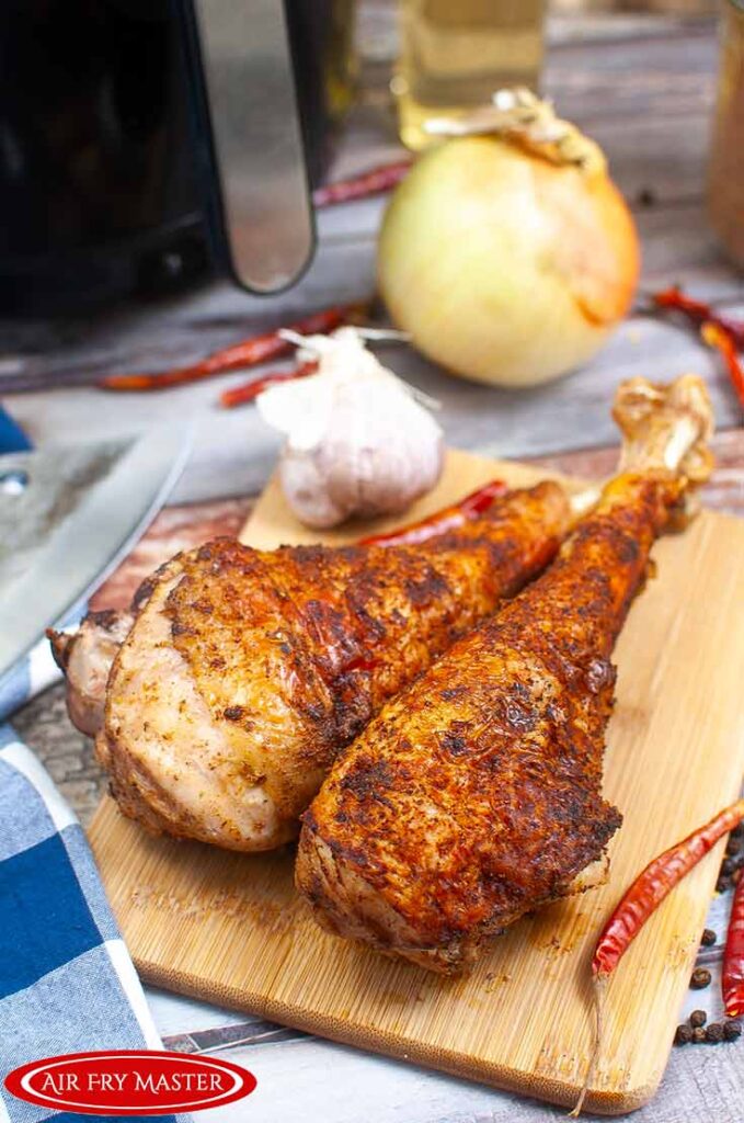 A front view of two turkey legs on a cutting board.